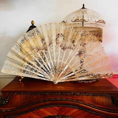 an antique fan sitting on top of a dresser