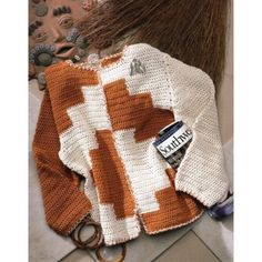 an orange and white knitted sweater with scissors on the floor