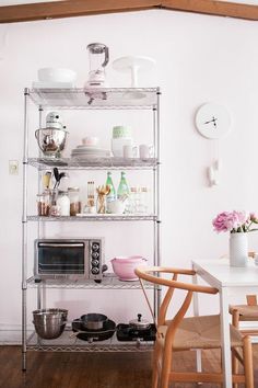 an instagram photo of a kitchen with pink walls and shelving in the background