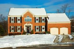 a large red brick house with wreaths on the windows