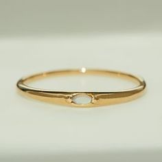 a gold ring with a white stone on it