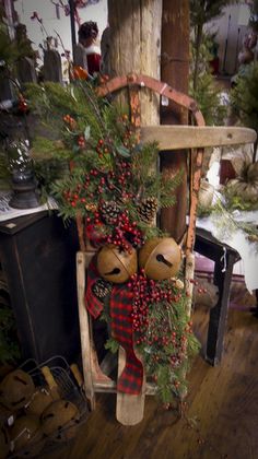 a wooden chair with christmas decorations on it and two teddy bears hanging from the back