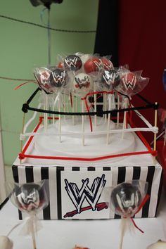 a table topped with lollipops and marshmallows on top of a cake