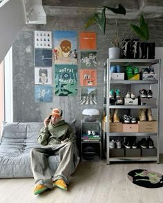 a man sitting on top of a couch next to a book shelf