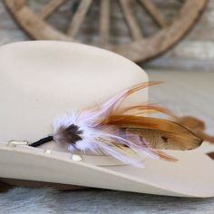 This handmade arrangement of feathers is the perfect way to set your hat apart from the rest. Simply tuck into the band of any hat. Made with a mix of pheasant tail and rooster feathers. Approximately 8 inches long, sizes may vary due to being made with natural materials.  Includes: 1 Handmade Arrangement of Feathers. How to use: Tuck into the hat band of any hat. *Each one will vary slightly due to being handmade. *Hat not included.  Natural Feathers * Approx. 8 inches - sizes may vary slightly Southwestern Feather Hat Band For Country Events, Western Wide Brim Top Hat With Feathers, Southwestern Hat Bands With Feathers For Ranch, Western Style Brimmed Top Hat With Feathers, Feathered Hats For Kentucky Derby And Country Events, Kentucky Derby Western Felt Hat With Feather Trim, Country Style Feathered Hat Bands For Western-themed Events, Country Style Felt Hat With Feathers For Rodeo, Country Style Hat Bands With Feathers For Western-themed Events