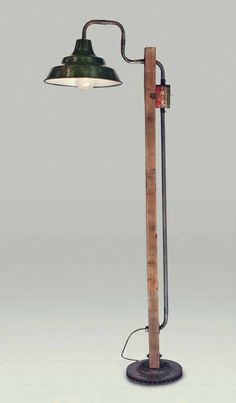 an old fashioned lamp with a wooden pole and metal shade on the top, against a white background