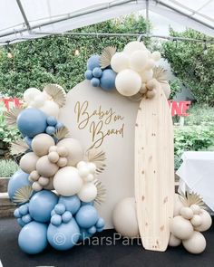 a surfboard and balloon arch for a baby shower