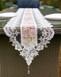 the table is decorated with white lace and pink flowers