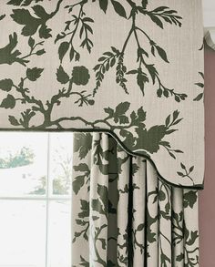 a window with green and white curtains in front of a window sill that has flowers on it