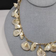 *Description: This is a white enamel over gold tone sea shell charm necklace with real or faux baroque pearls and 8mm faux pearls on the extension chain from the 1950s. This necklace has the same charms as a Napier necklace without the white enamel. I can not find another one like it. This is very similar to this Napier necklace with the same shape of clam and oyster shells but this necklace is unsigned. The pearls may be real baroque or may be faux. No matter which is accurate, it is a wonderfu Vintage Shell Gold Jewelry, Vintage Gold Shell Jewelry, Vintage Shell Shaped Jewelry, Vintage White Shell Necklace, Vintage Gold Shell, Vintage Mother Of Pearl Shell Jewelry, Vintage Pearl Jewelry With Lobster Clasp, Shell Charm Necklace, Formal Earrings