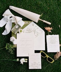 the wedding stationery is laid out on the grass