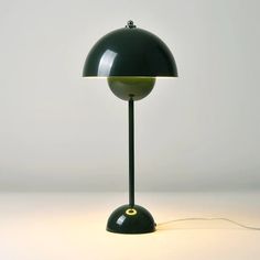 a black lamp with a green shade on it