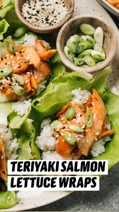 lettuce wraps filled with salmon and rice on a plate next to small bowls