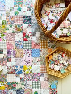 a basket sitting on top of a table next to a wall covered in patchwork