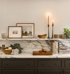 a kitchen counter with candles and pictures on it