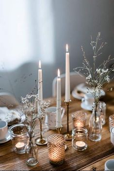 a wooden table topped with candles and dishes