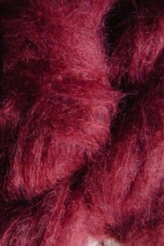 a close up view of the texture of a red woolen yarn or felting material