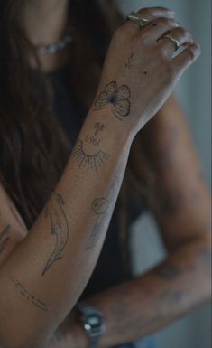 a woman with tattoos on her arm and wrist