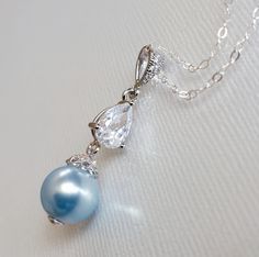 Light Blue Blush Blue Pearl Drop Silver Cubic Zirconia Wedding Bridal Pendant Necklace with .925 Sterling Silver Chain. PLEASE READ ITEM DESCRIPTION and SHOP POLICIES before placing your order, and contact me with any questions CHAIN is 20 inches (50.8cm) long. PENDANT is about 1.29 inch (3.3cm) long including bail. MATCHING EARRINGS: https://www.etsy.com/listing/529633883/blush-blue-pearl-earrings-light-blue?click_key=05ee615b36def4bf22e63d31c29c3cc1e7fccf02%3A529633883&click_sum=8b6b5e29&ref=shop_home_active_58&sts=1 BRIDAL NECKLACES SECTION: https://www.etsy.com/shop/LanaChayka?ref=seller-platform-mcnav§ion_id=11638944 BRIDAL EARRINGS SECTION: https://www.etsy.com/shop/LanaChayka?ref=seller-platform-mcnav&section_id=11638940 BRIDAL JEWELRY SETS SECTION: https://www.etsy.com/shop/LanaCha Silver Necklace Wedding, Bridal Pendant Necklace, Blue Pearl Necklace, Pearl Silver Necklace, Blue Pearl Earrings, Bridal Necklaces, Blue Wedding Jewelry, Bridal Pendant, Wedding Blue