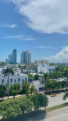 an aerial view of a city with tall buildings and palm trees in the foreground