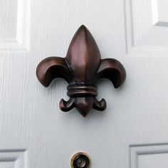 a fleur de lis door handle on a white door