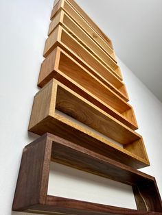 a stack of wooden shelves sitting on top of a wall next to a white wall