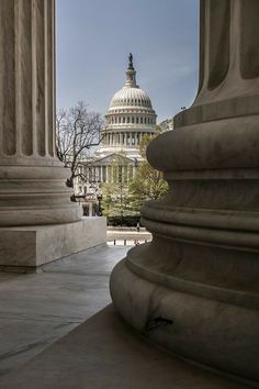 the capital building is seen through some pillars