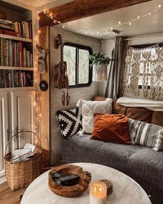 a living room with a couch, table and bookshelf in the background text reads family turned wineabo motorhome into boho chic cottage on wheels and slash their living