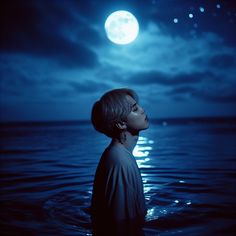 a person standing in the water at night with a full moon behind them and stars above