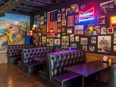 the interior of a restaurant with purple leather booths and pictures on the wall behind them