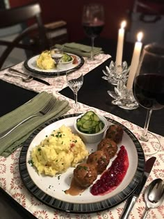 a dinner plate with meat, mashed potatoes and gravy next to a glass of wine