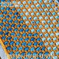 a crocheted tablecloth with blue and yellow yarn