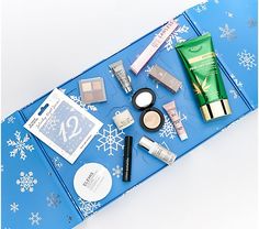 the contents of a travel bag laid out on top of a blue blanket with snowflakes