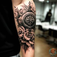 a man with a compass and roses tattoo on his arm