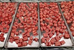 two pans filled with red food sitting on top of a counter next to each other