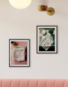 two framed photographs hang on the wall above a pink bench in a dining room with white walls