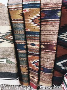 several rugs are lined up in rows on the floor and one has fringed ends