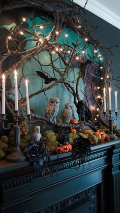 an ornate mantle with candles and owls on it