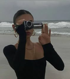 a woman taking a photo with her camera on the beach