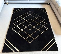 a black and white rug on the floor next to a couch in a living room