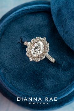 an engagement ring in a velvet box with the words dana rae jewelry on it