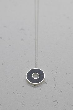 Unique round necklace is made of sterling silver frame filled with dark gray resin & concrete mix.  Concrete has slightly rough natural texture and matte finish. Measurements: Pendant Size: 18 mm / 0.7 " Necklace length: 50 cm I'm using a concrete and resin mix, to obtain a stronger material.  It is hypoallergenic and waterproof. Find similar necklaces here:  http://etsy.me/2cTPGpL Find matching rings here:  http://etsy.me/2dd8zba Want to see more jewelry from my shop? click here: http://etsy.me Minimalist Gray Sterling Silver Jewelry, Cement Jewelry, Concrete Necklace, Half Moon Necklace, Concrete Ideas, Concrete Jewelry, Gold Circle Necklace, Necklace Resin, Long Statement Necklace