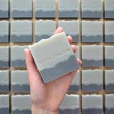 a hand holding up a gray tile with words on it