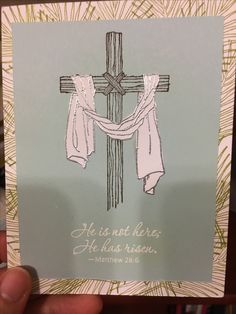 a hand holding up a card with a cross on it