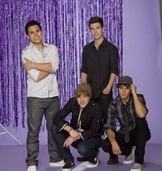 three young men posing for a photo in front of purple tinsel curtain backdrops