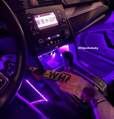 the interior of a car is lit up with purple lights and features an electronic display