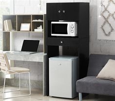 a microwave oven sitting on top of a desk next to a chair