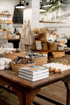 a wooden table topped with lots of books and baskets filled with food on top of it