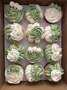 a box filled with cupcakes covered in green frosting and white icing