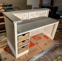 an unfinished desk with drawers on top of it in the process of being painted and assembled